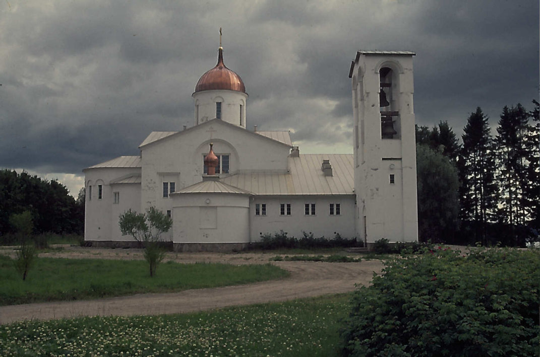 Valkoinen iso kirkko jossa edessä kellotorni ja katolla kullattu kupoli.