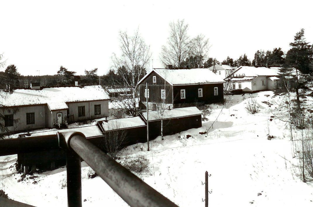 Talvinen ylhäältä otettu kuva viidestä puurakennuksesta.